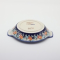 Round baking dish with handles made of Boleslawiec pottery.