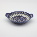 Round baking dish with handles made of Boleslawiec pottery.