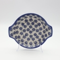 Round baking dish with handles made of Boleslawiec pottery.