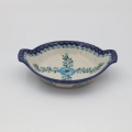 Round baking dish with handles made of Boleslawiec pottery.