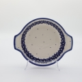 Round baking dish with handles made of Boleslawiec pottery.