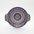 Round baking dish with handles made of Boleslawiec pottery.