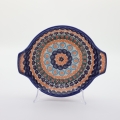 Round baking dish with handles made of Boleslawiec pottery.