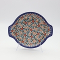 Round baking dish with handles made of Boleslawiec pottery.
