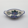 Round baking dish with handles made of Boleslawiec pottery.