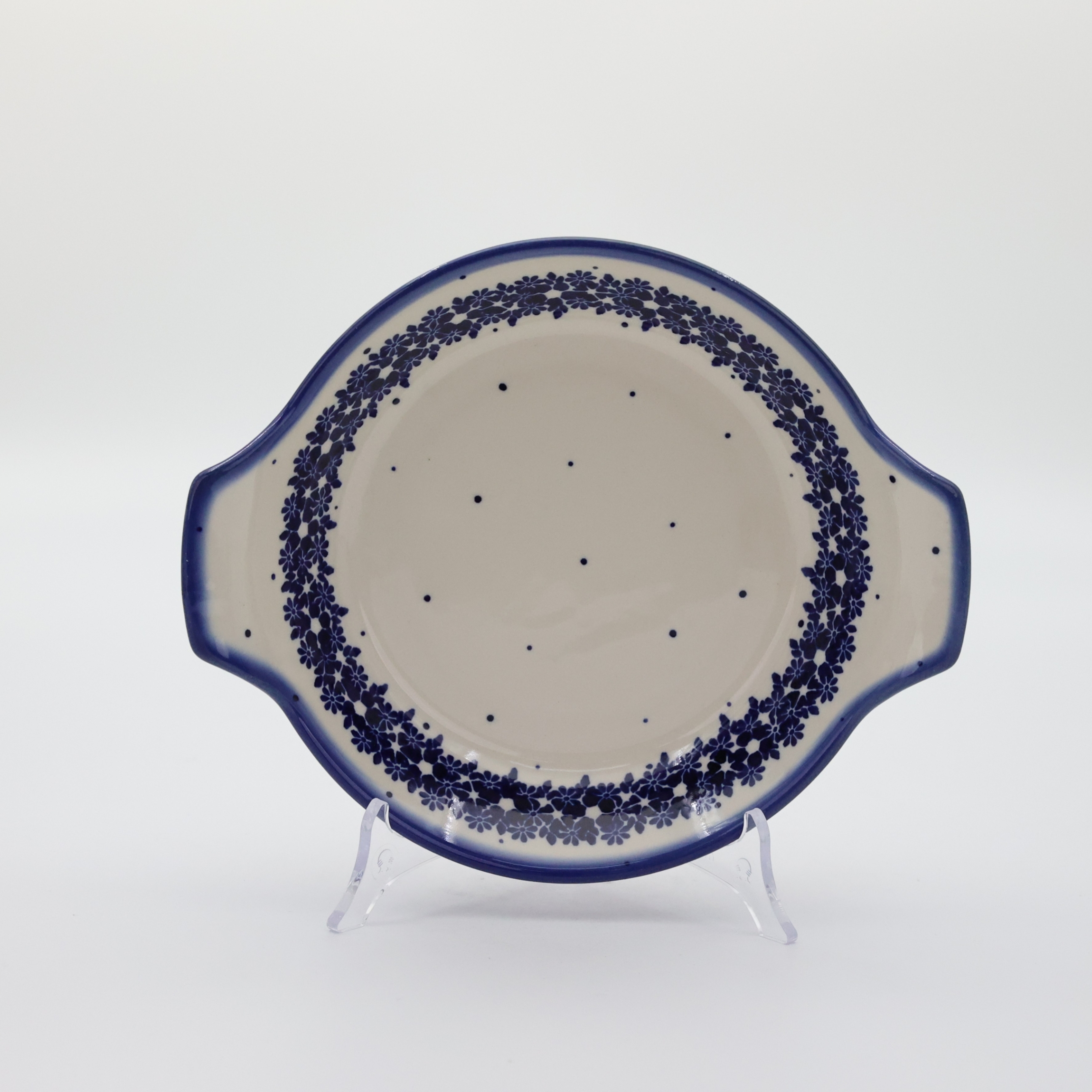 Round baking dish with handles made of Boleslawiec pottery.